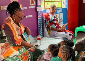 Minister Siviwe Gwarube reads to children at a local school.