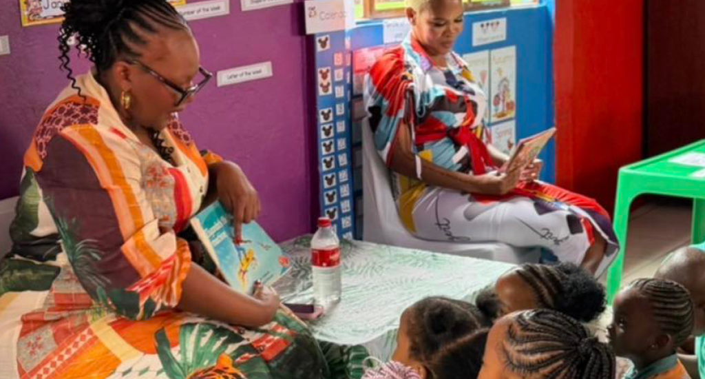 Minister Siviwe Gwarube reads to children at a local school.